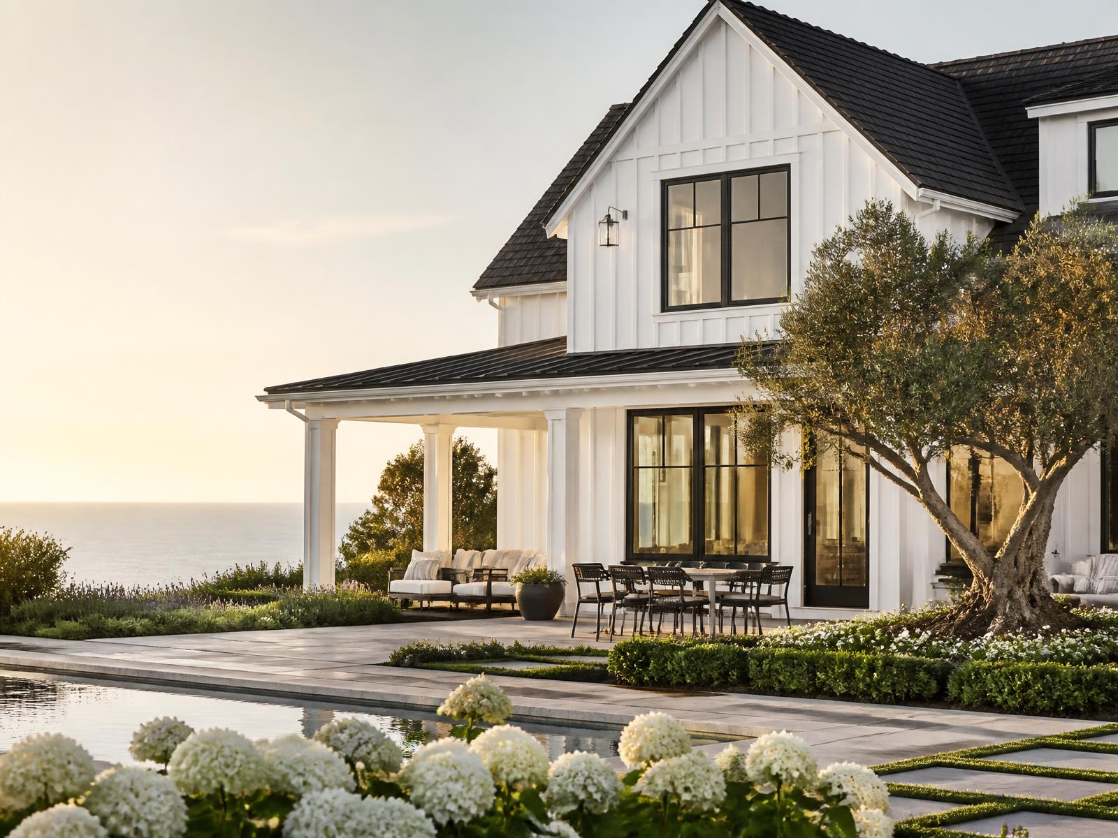 White coastal farmhouse with pool and ocean view at golden hour